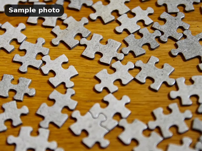Sample photo: blank white jigsaw puzzle pieces on a wooden table. Not Platinum Prints work.